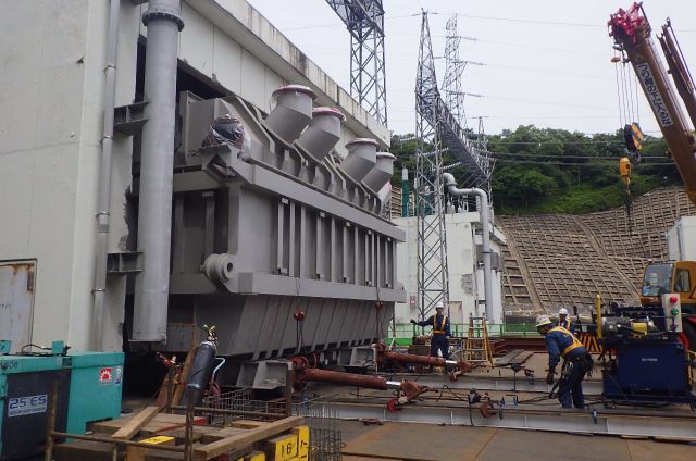 クレーンによる大型機材のトレーラ積載作業